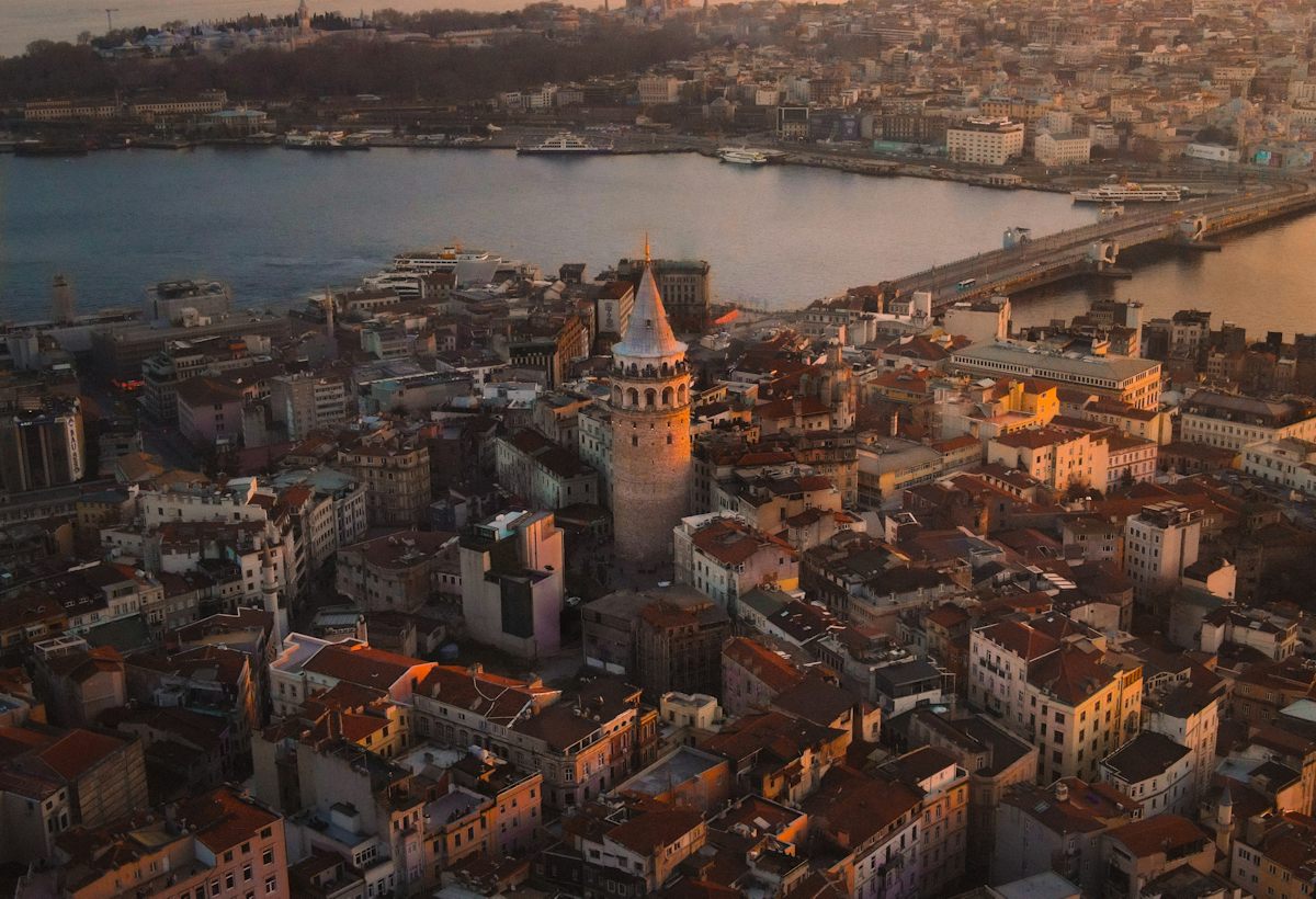 Gün batımında Galata Kulesi ve çevresindeki yoğun konut dokusu, arkada Haliç ve tarihî yarımada