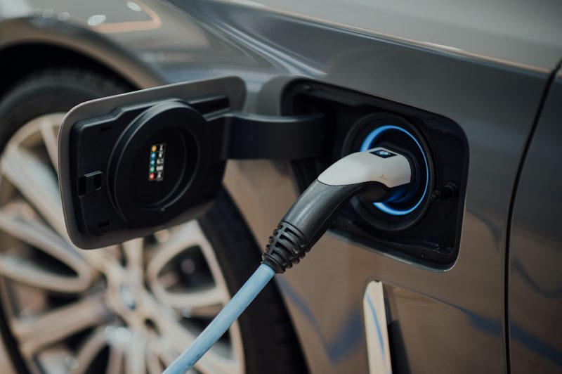 Bir elektrikli otomobilin şarj soketine takılı şarj kablosu