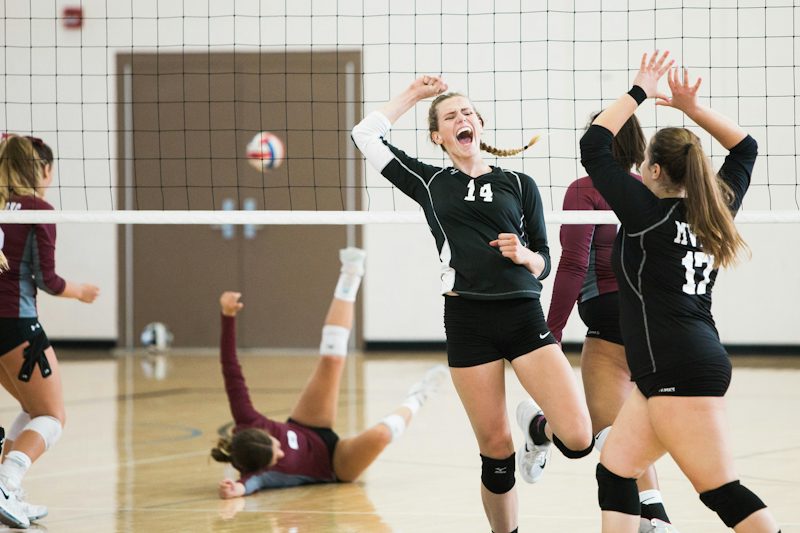 Kapalı salonda sayı sonrası sevinen kadın voleybolcular